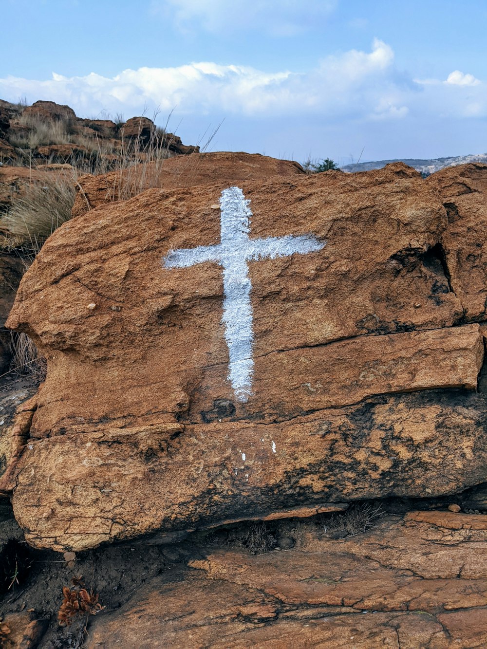 white cross on brown rock