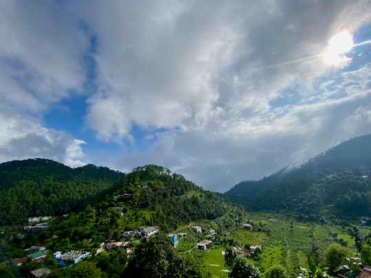 green mountains under white clouds during daytime in Nainital India
