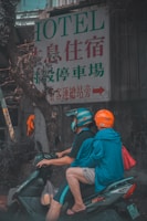 man in red t-shirt and orange helmet sitting on motorcycle