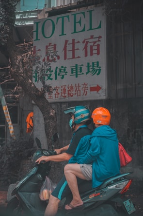 man in red t-shirt and orange helmet sitting on motorcycle