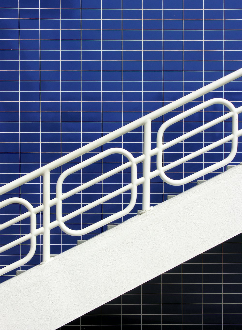 white metal railings on blue concrete wall