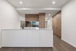 a large kitchen with a white counter top and wooden cabinets