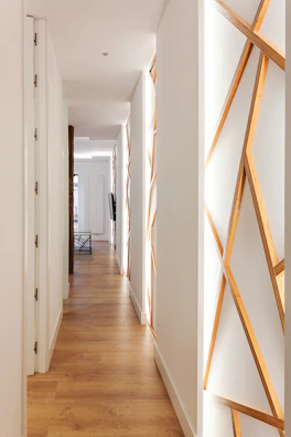 A sleek laminate floor installation in a bright, airy hallway.