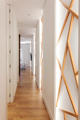 A clean, modern apartment hallway with soft pastel walls and neat finishing touches.