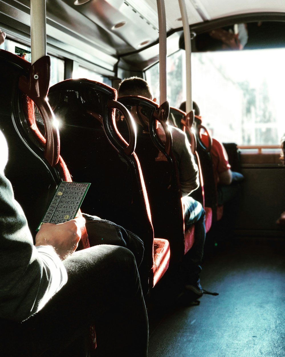 man in black jacket sitting on bus seat