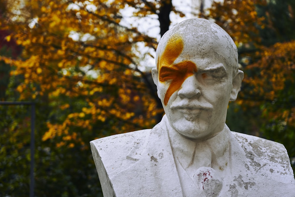 white concrete statue near brown trees during daytime