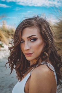 Casual daytime look featuring tousled hair and fresh, dewy makeup on a model by the Mediterranean coast