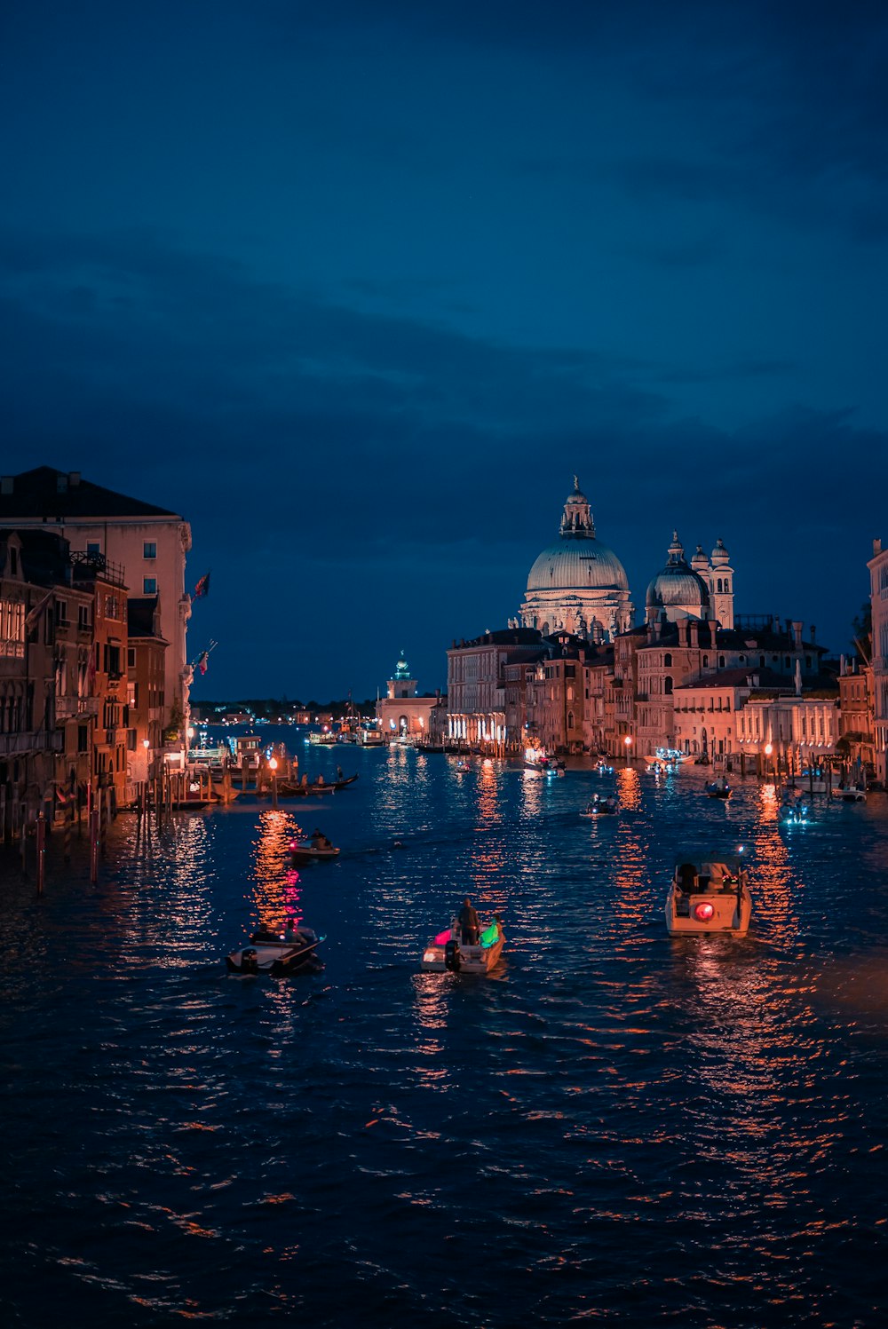 people riding on boat on river near buildings during night time