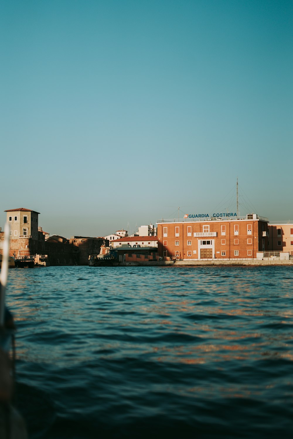 brown concrete building beside body of water during daytime