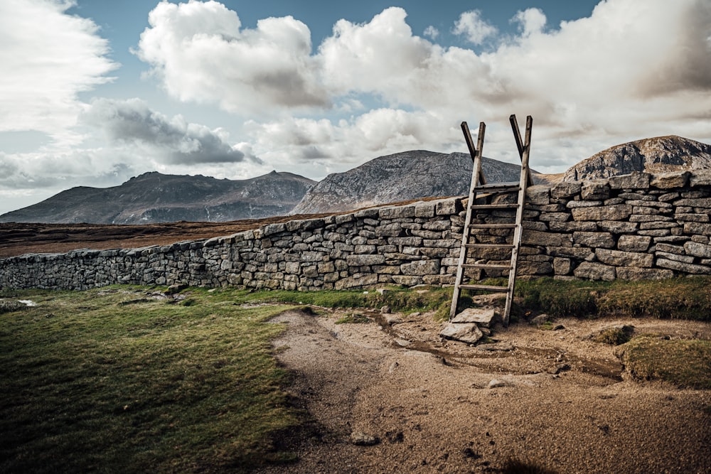 brown wooden fence on brown soil under white clouds and blue sky during daytime