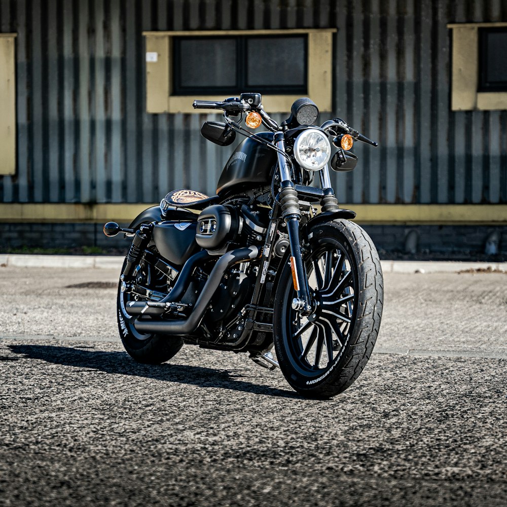 black and silver cruiser motorcycle parked on gray concrete road during daytime