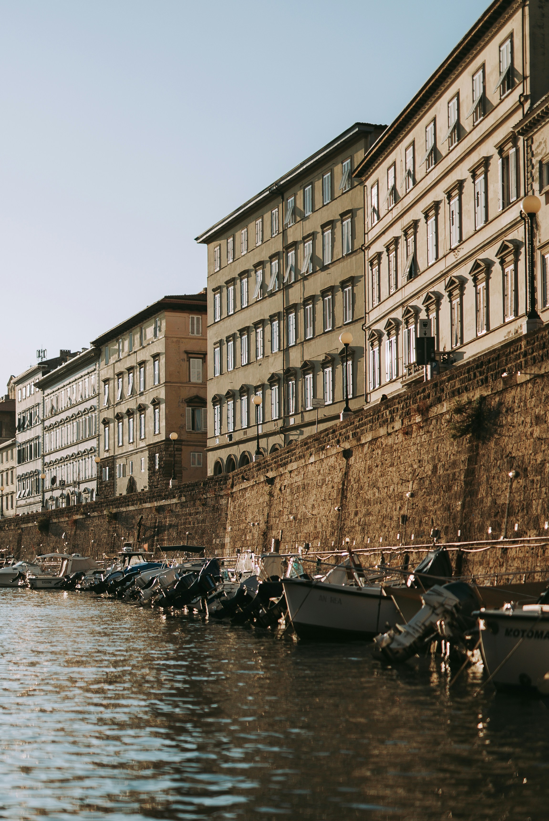 people riding on boat on river near brown concrete building during daytime