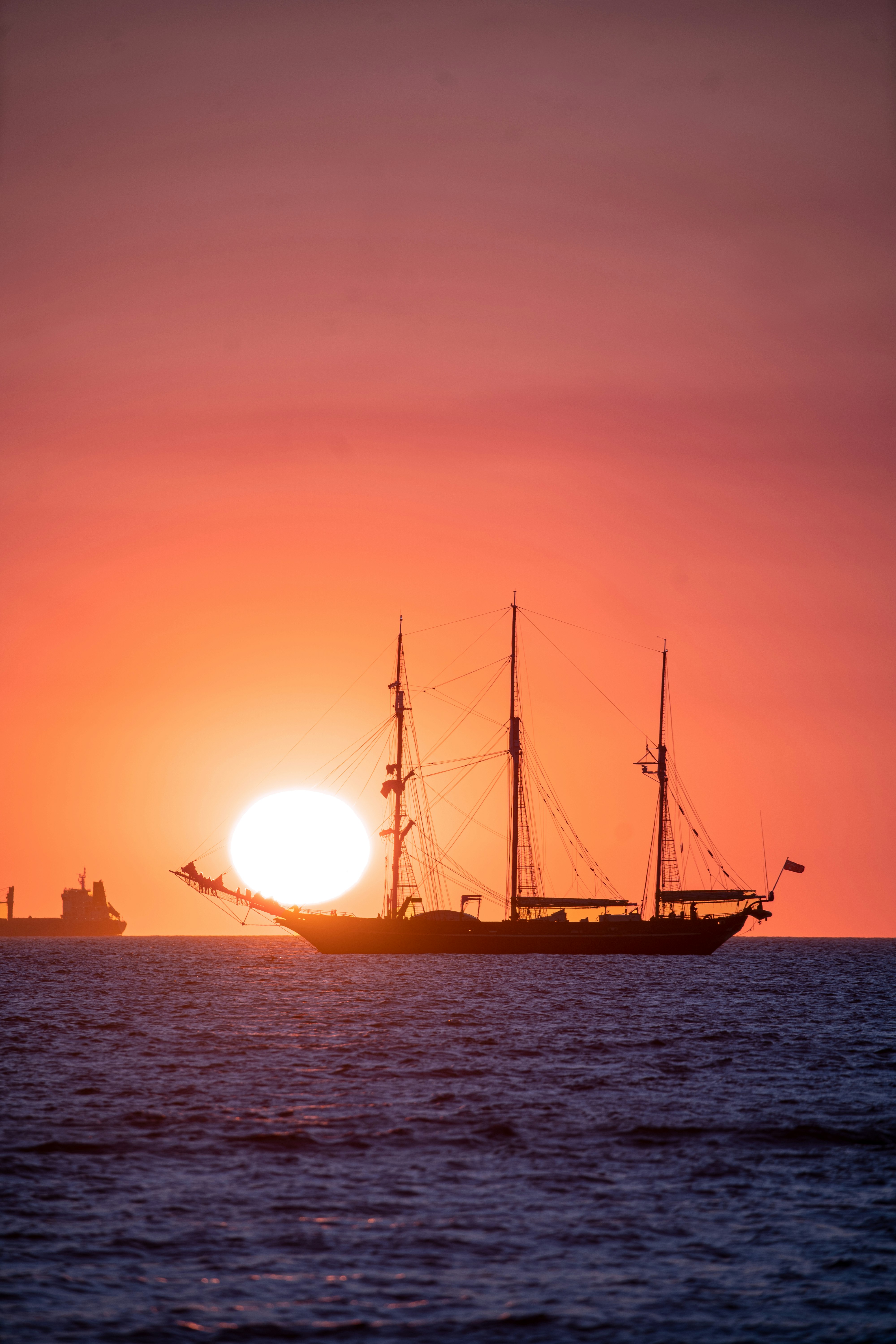 silhouette of ship on sea during sunset