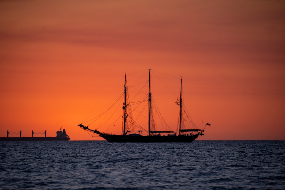 夕暮れ時の海上の船のシルエット