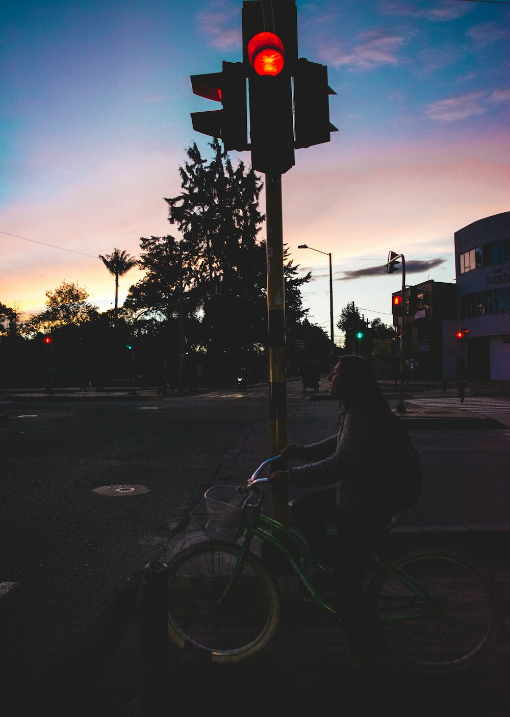 person riding bicycle on road during sunset