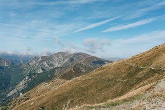 A panoramic shot of the rugged trail winding through Tetebatu’s rolling hills under a bright blue sky.