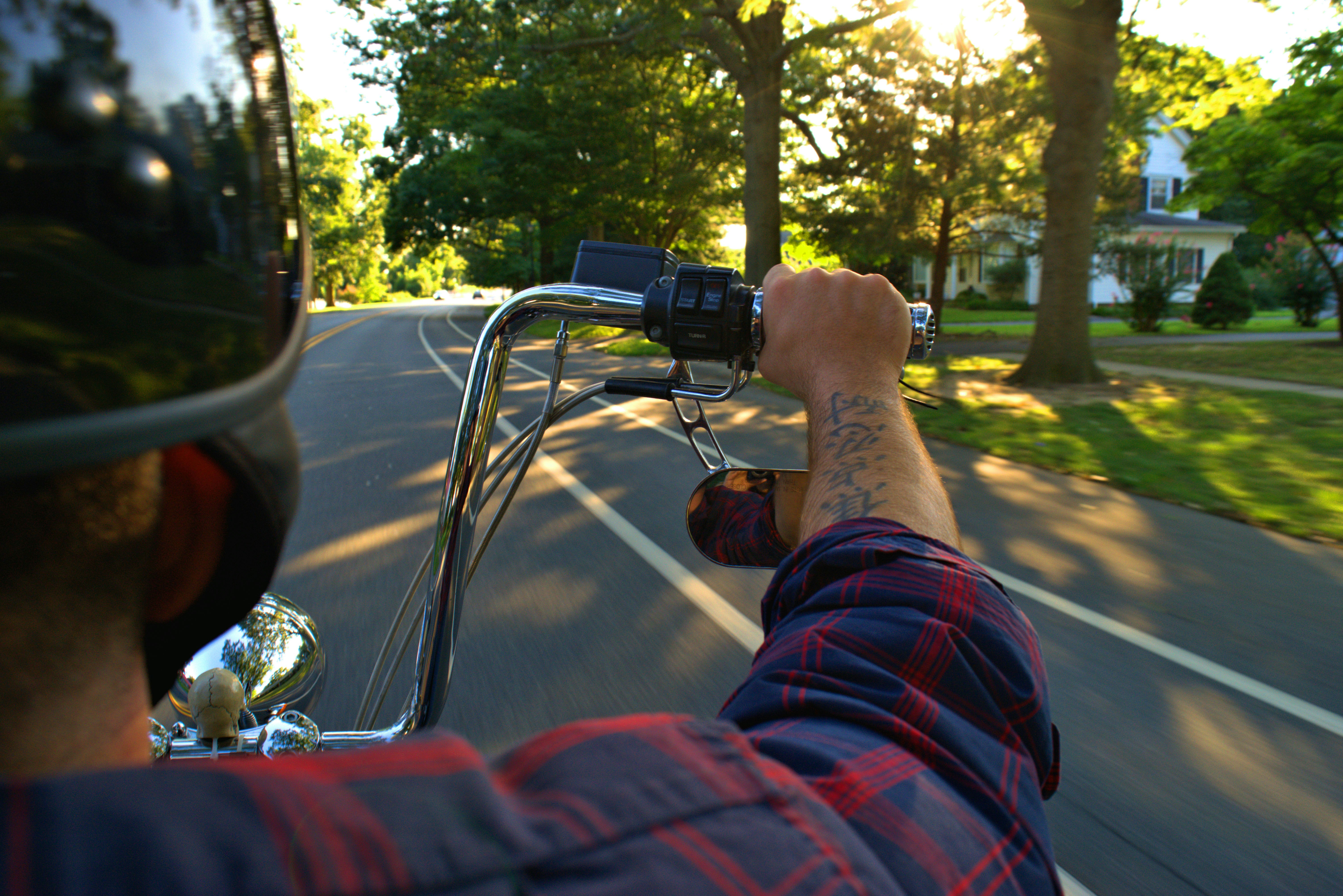Uomo in camicia a maniche lunghe blu e rossa che tiene la fotocamera DSLR nera