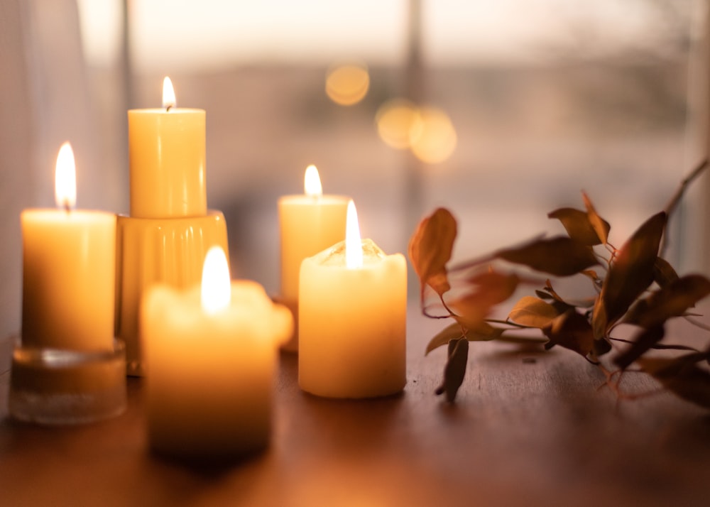 white pillar candles on brown wooden table