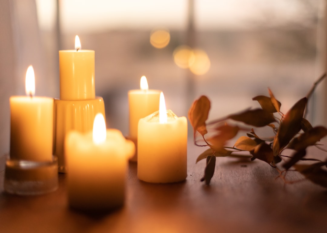  white pillar candles on brown wooden table candle