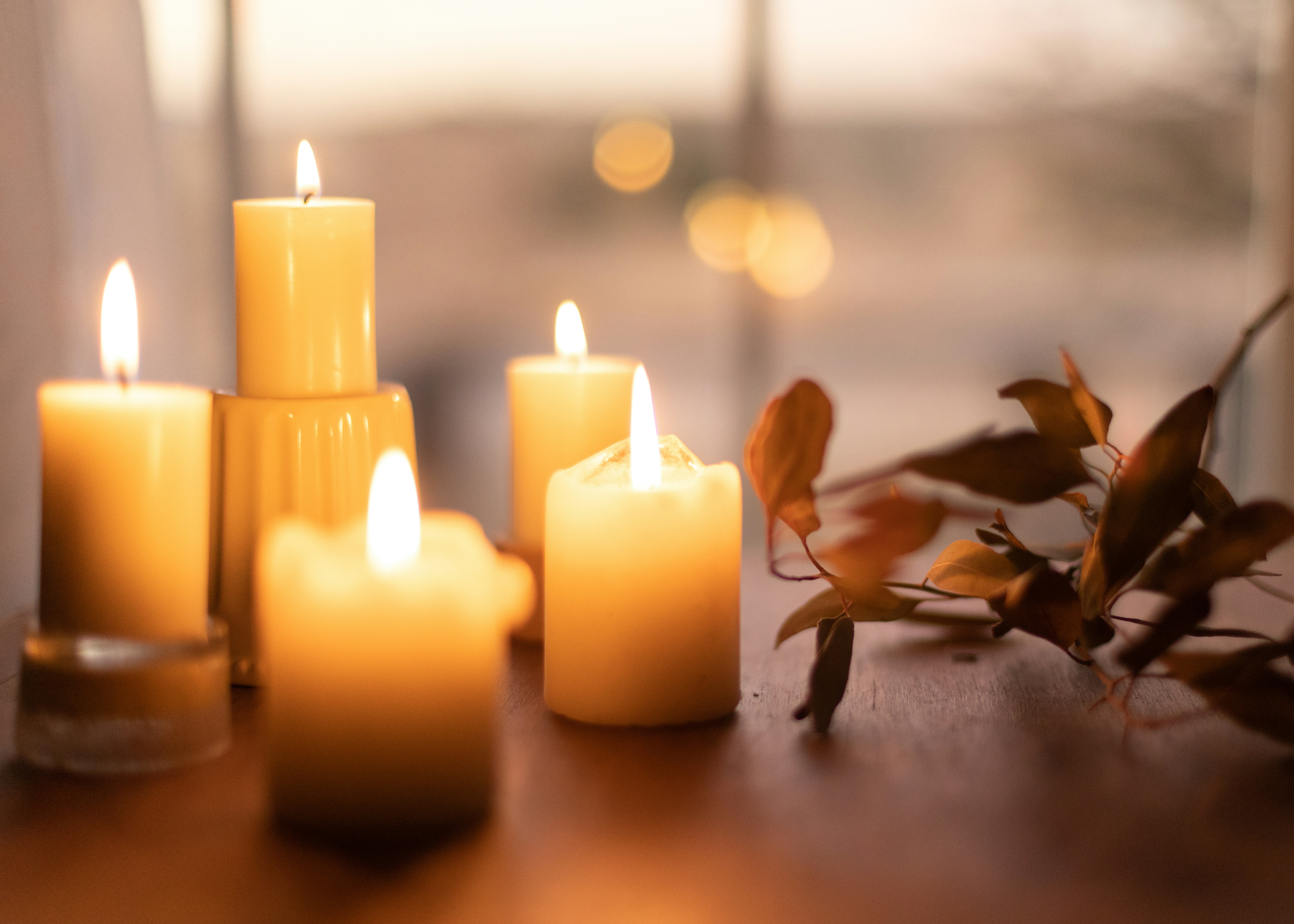 white pillar candles on brown wooden table