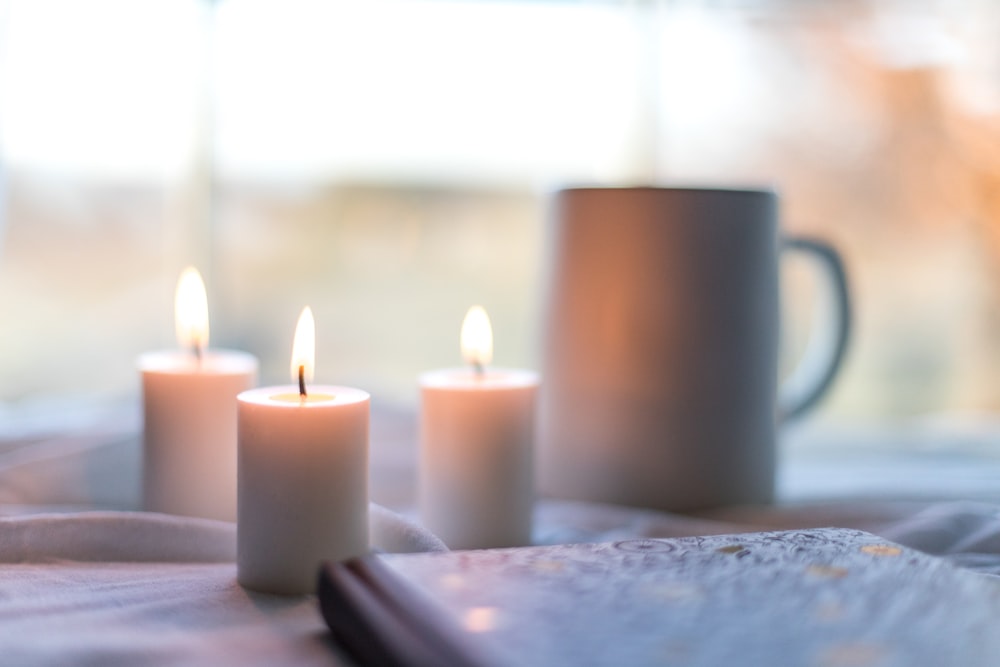 white pillar candles on white table