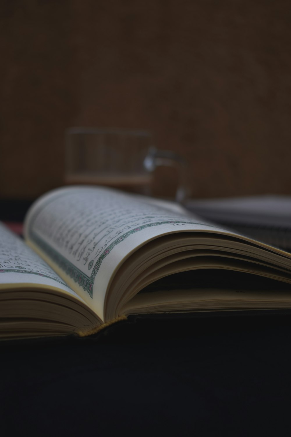 opened book on brown wooden table