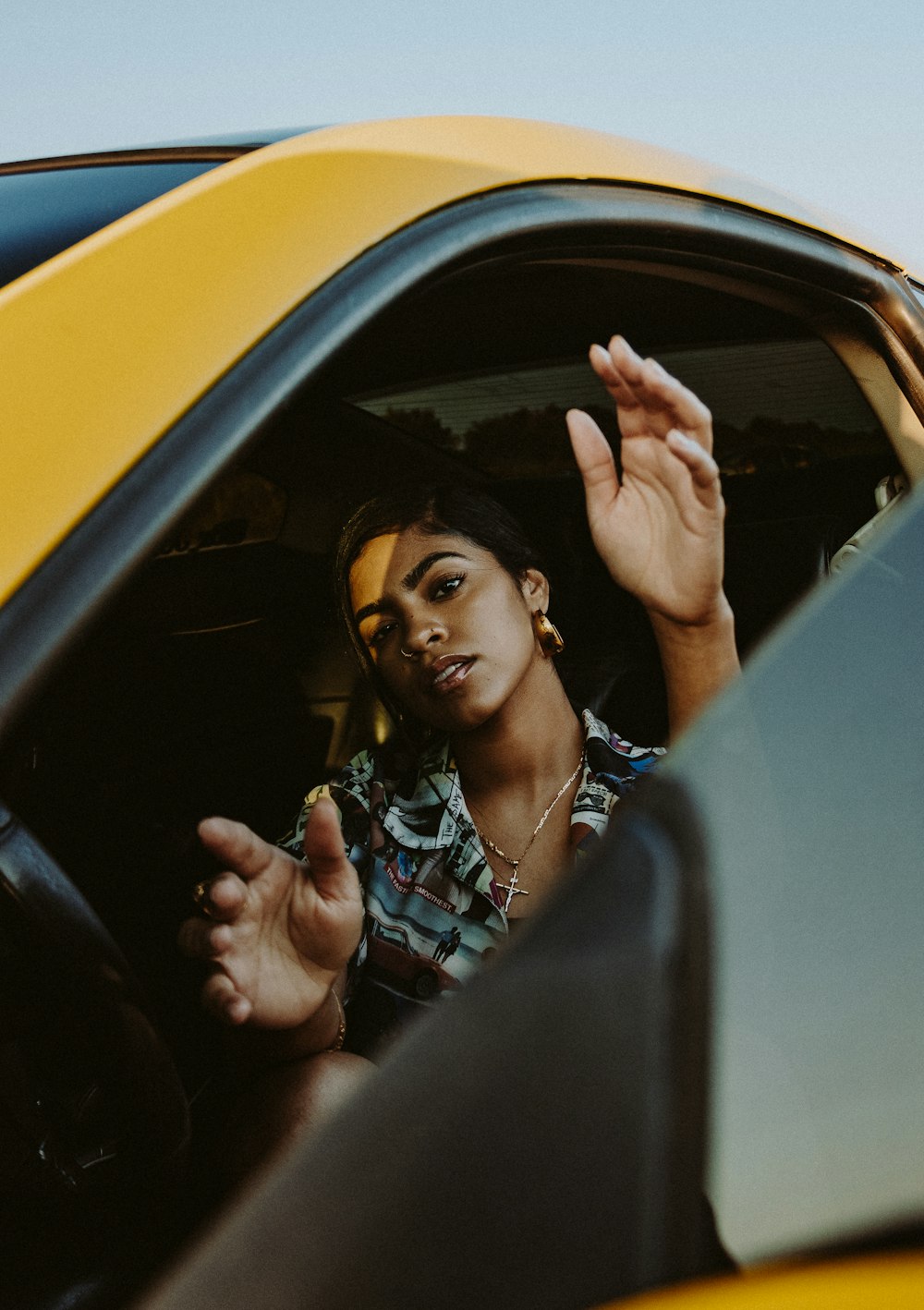 man in blue and white plaid button up shirt sitting inside car