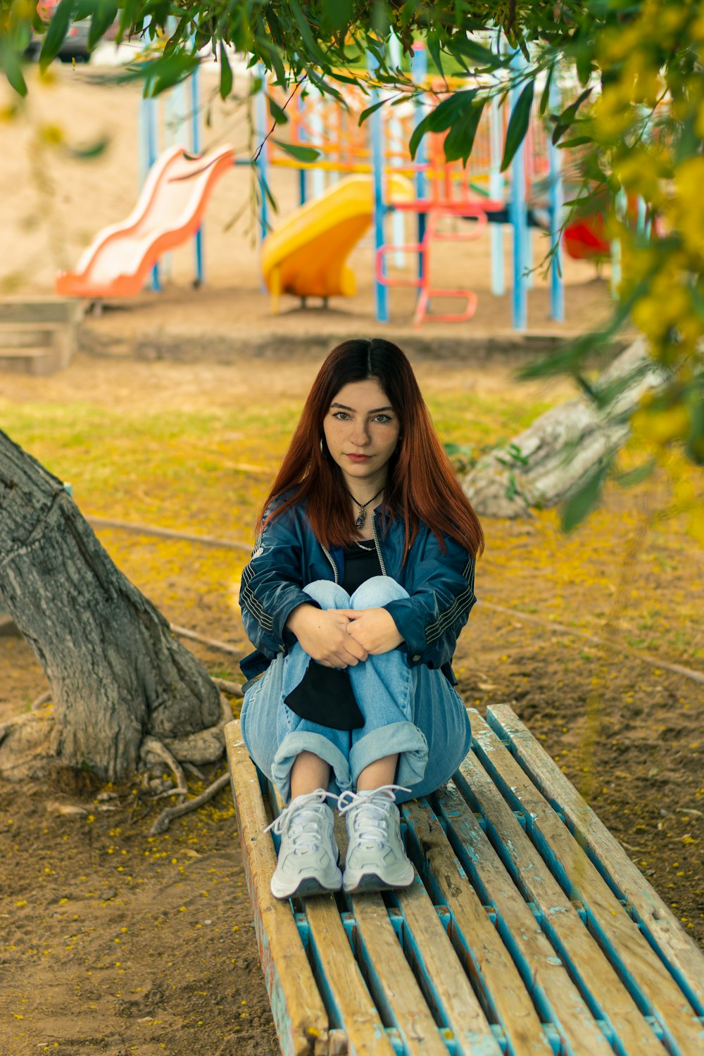 woman in black jacket sitting on brown wooden bench