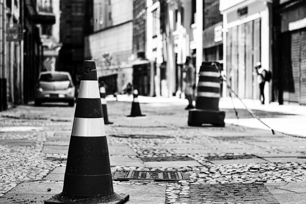 grayscale photo of traffic cone on road