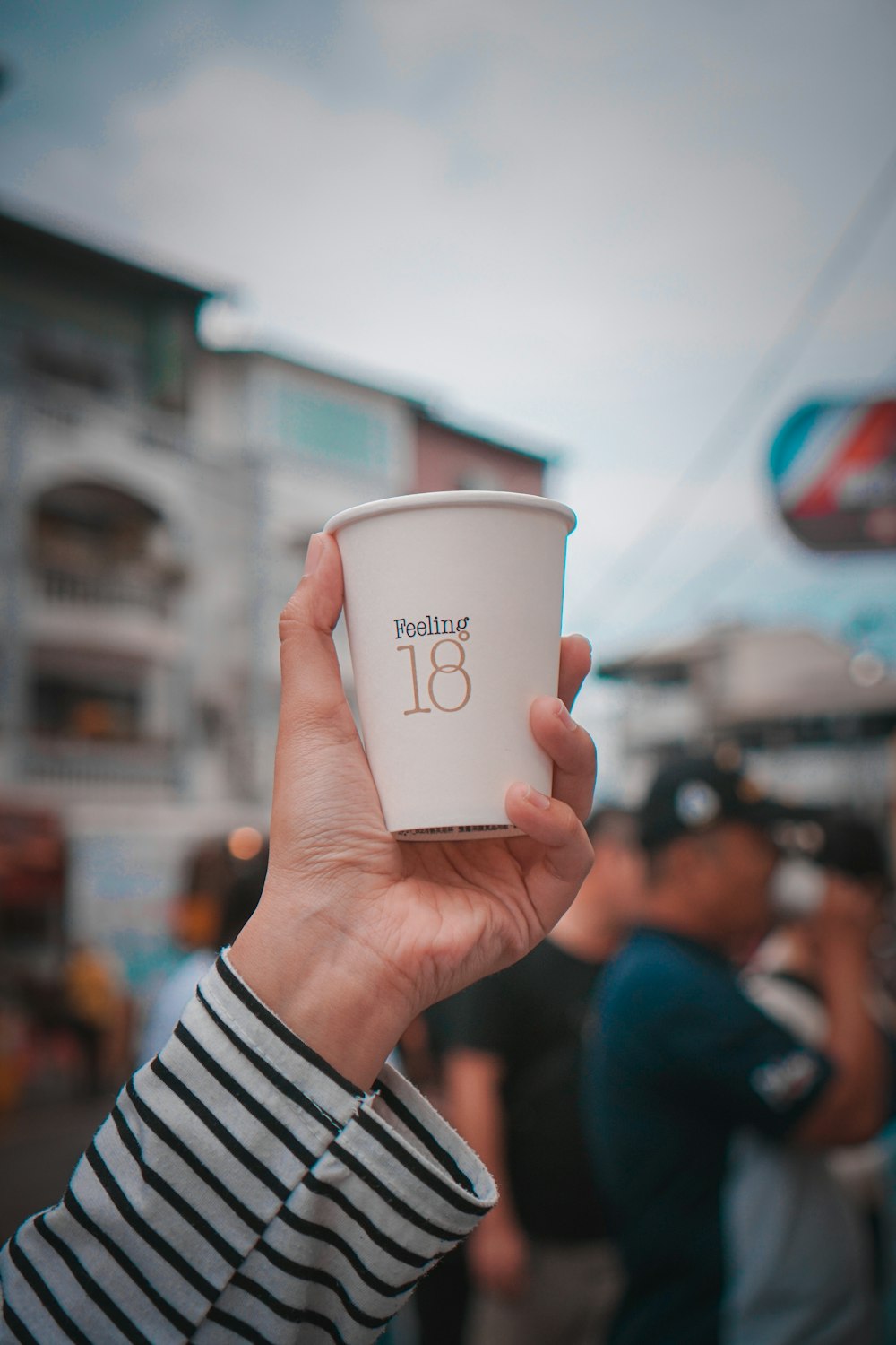 person holding white disposable cup