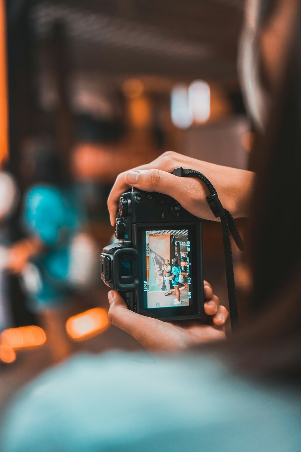 Person mit schwarzer DSLR-Kamera