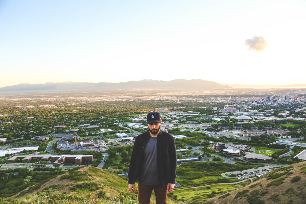 man in black coat standing on green grass field during daytime