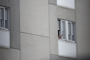 A satisfied middle-aged man giving thumbs up beside an air conditioning unit.