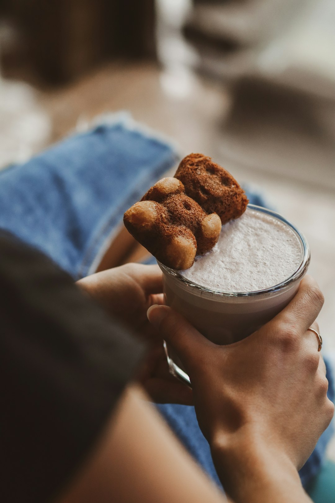 person holding clear glass cup with brown liquid