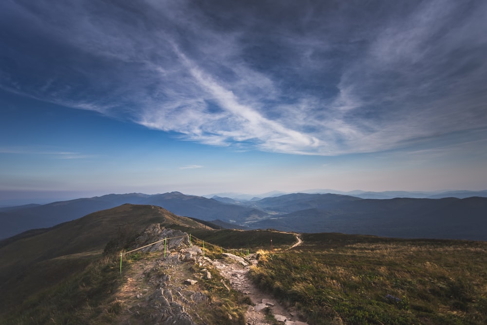 montagne verdi e marroni sotto il cielo blu durante il giorno