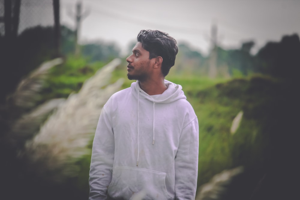 man in white hoodie standing during daytime