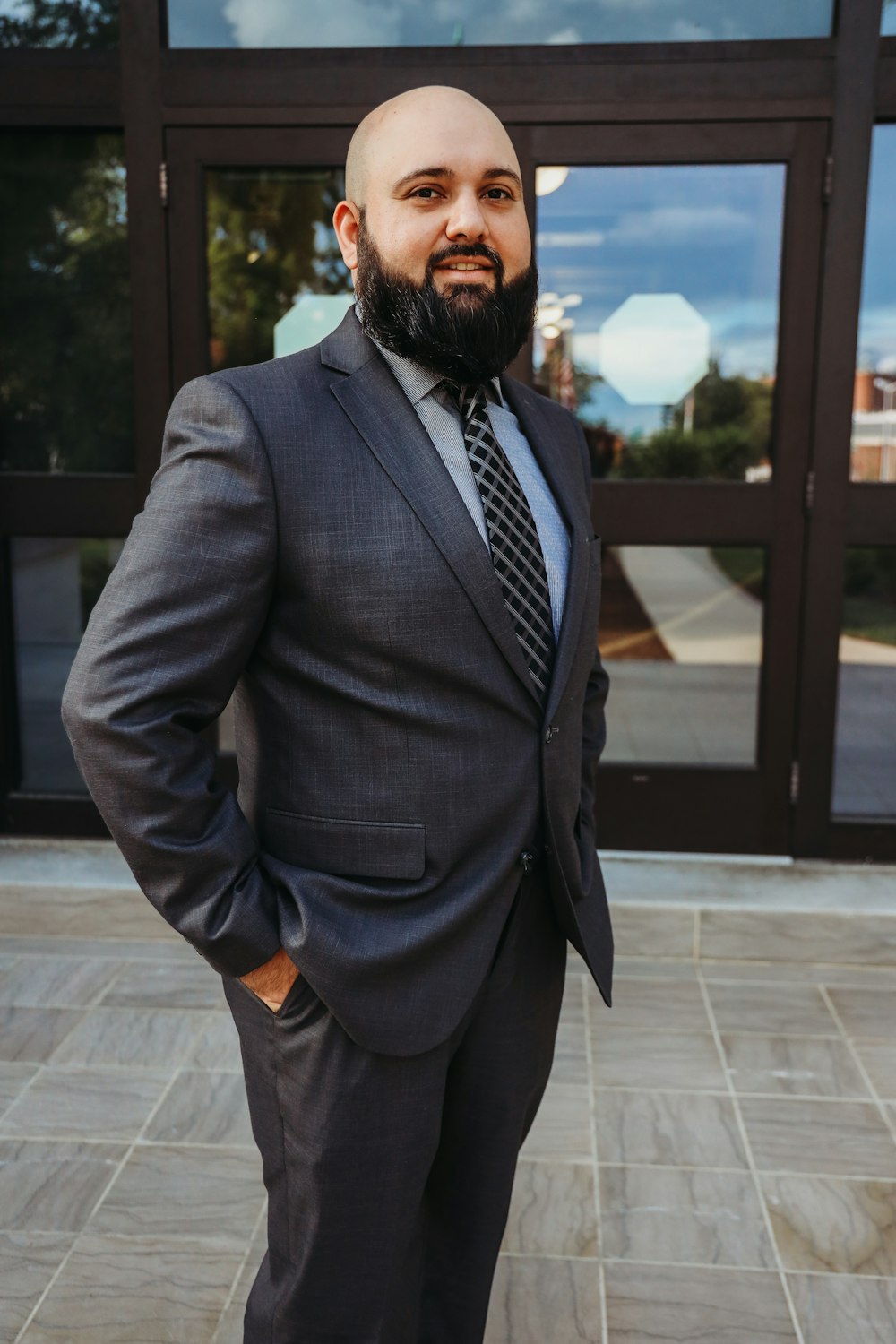 man in gray suit standing on gray concrete floor during daytime