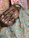 Close-up of elegant handcrafted Punjabi jutti with gold and emerald embroidery under warm lighting