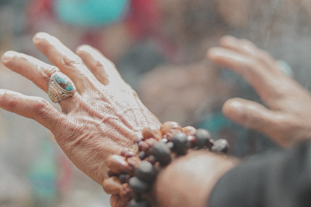 person with silver ring with blue stone