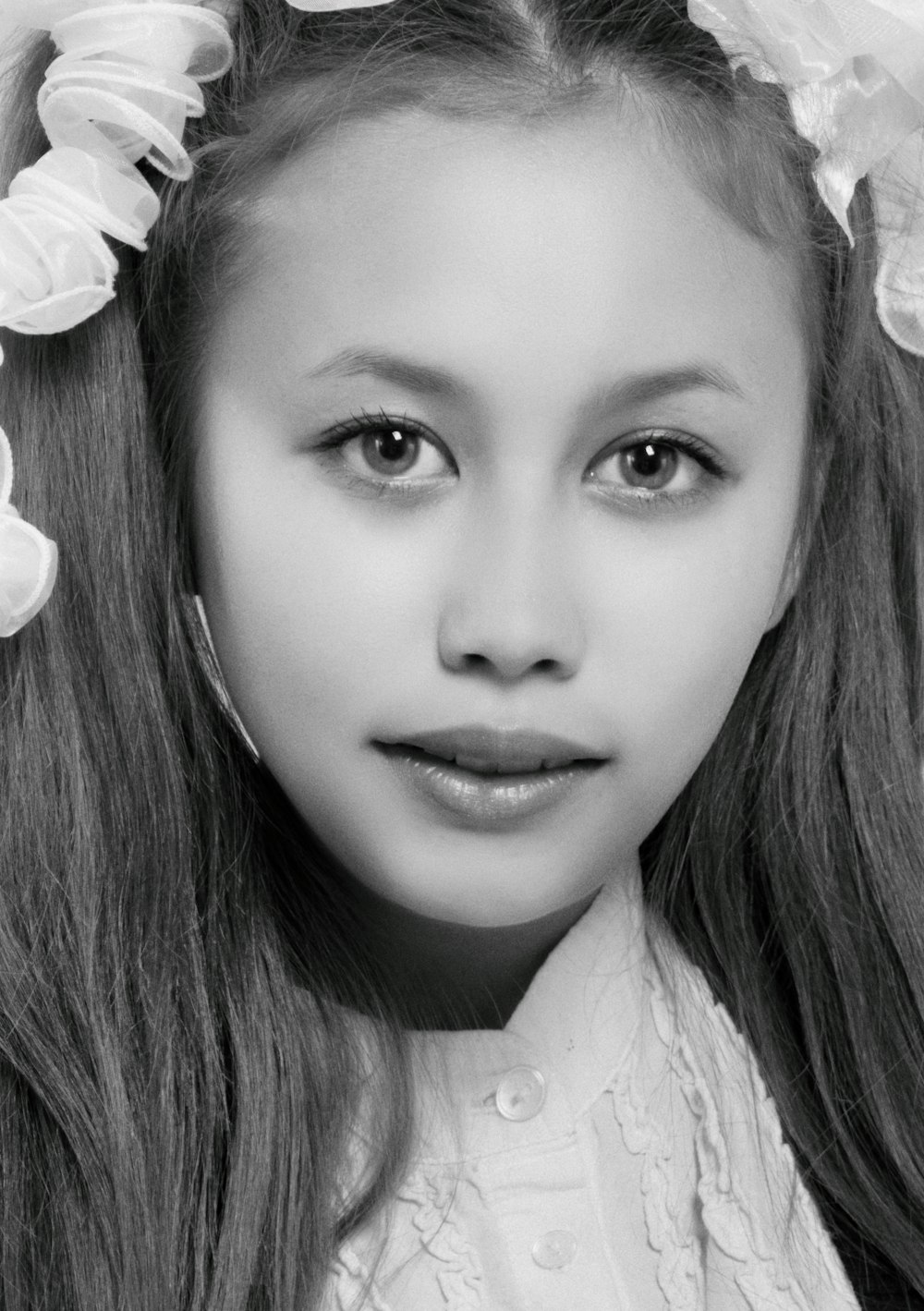 woman in white shirt with white flower on her ear