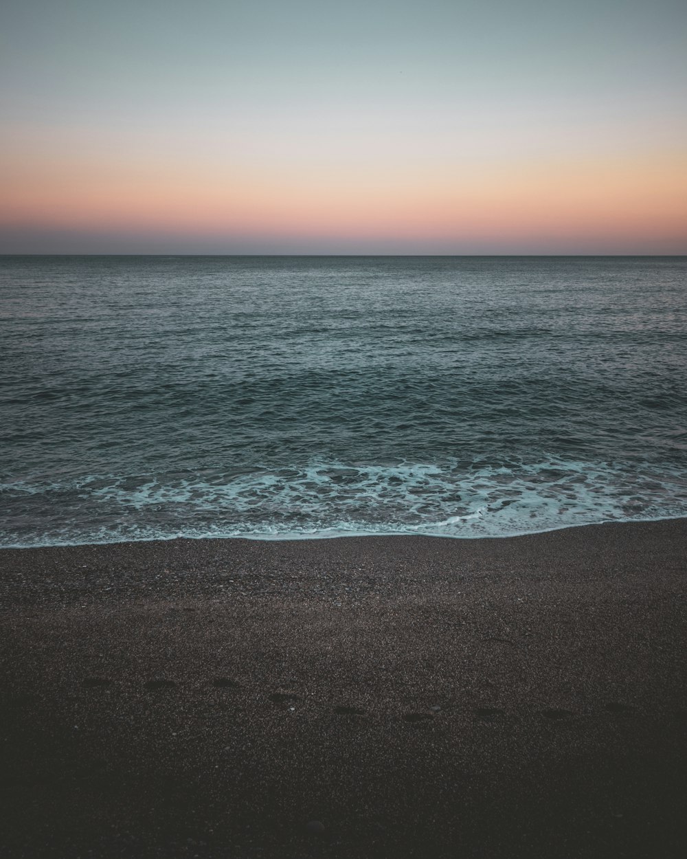 sea waves crashing on shore during sunset