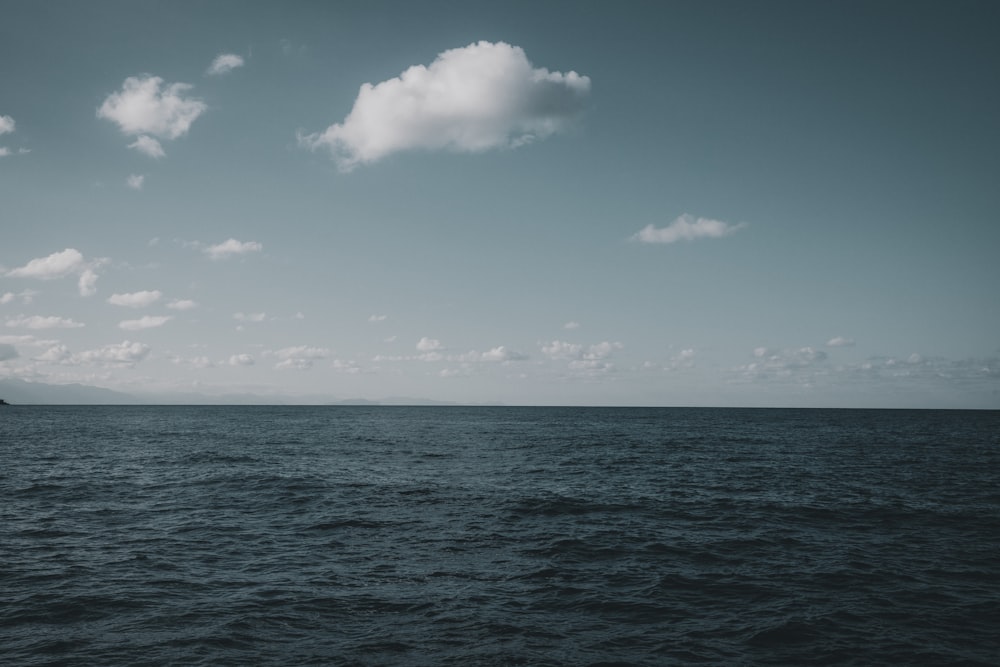 blue ocean under blue sky and white clouds during daytime