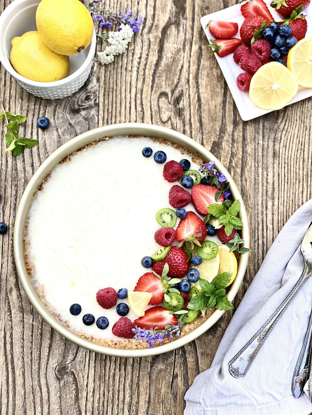 strawberries and sliced lemon on white ceramic bowl