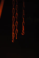 Broken chains lying on dark stone, illuminated by a warm, hopeful light.