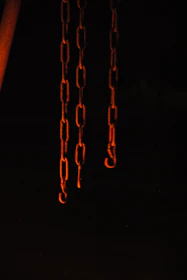 Broken chains lying on dark stone, illuminated by a warm, hopeful light.