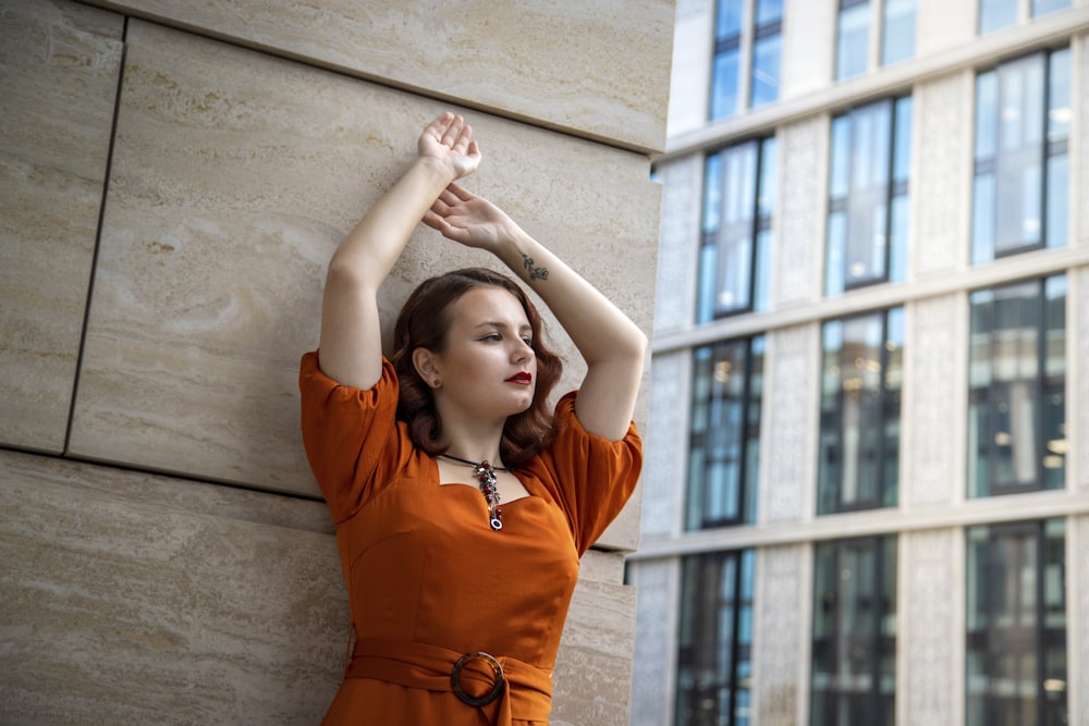 woman in orange long sleeve shirt raising her hands