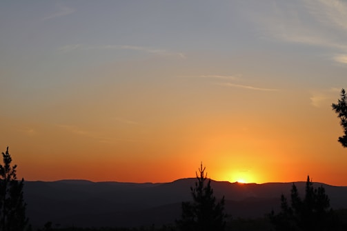 A tranquil sunset over a mountain range, symbolizing peace.