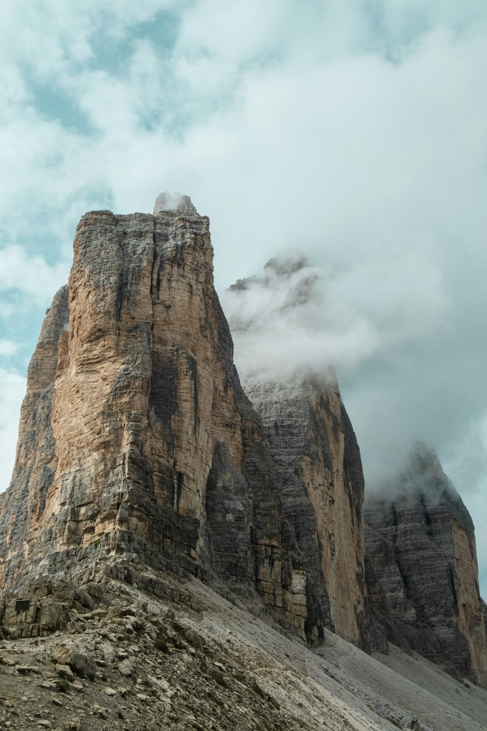 brown rocky mountain under white clouds during daytime