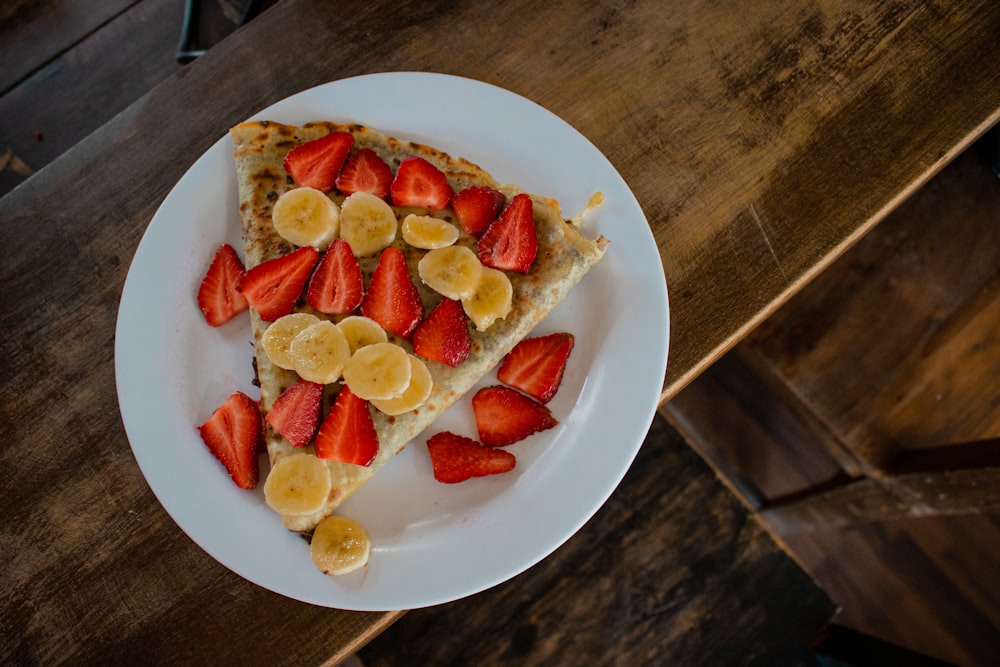 sliced strawberries and banana on white ceramic plate