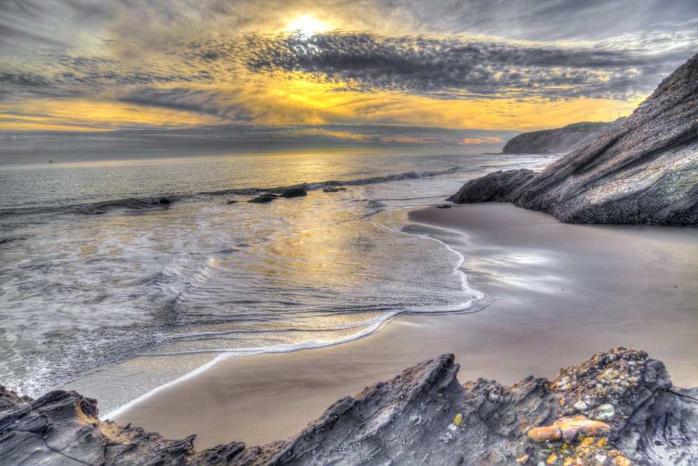 Olas del océano rompiendo en la costa durante la puesta de sol